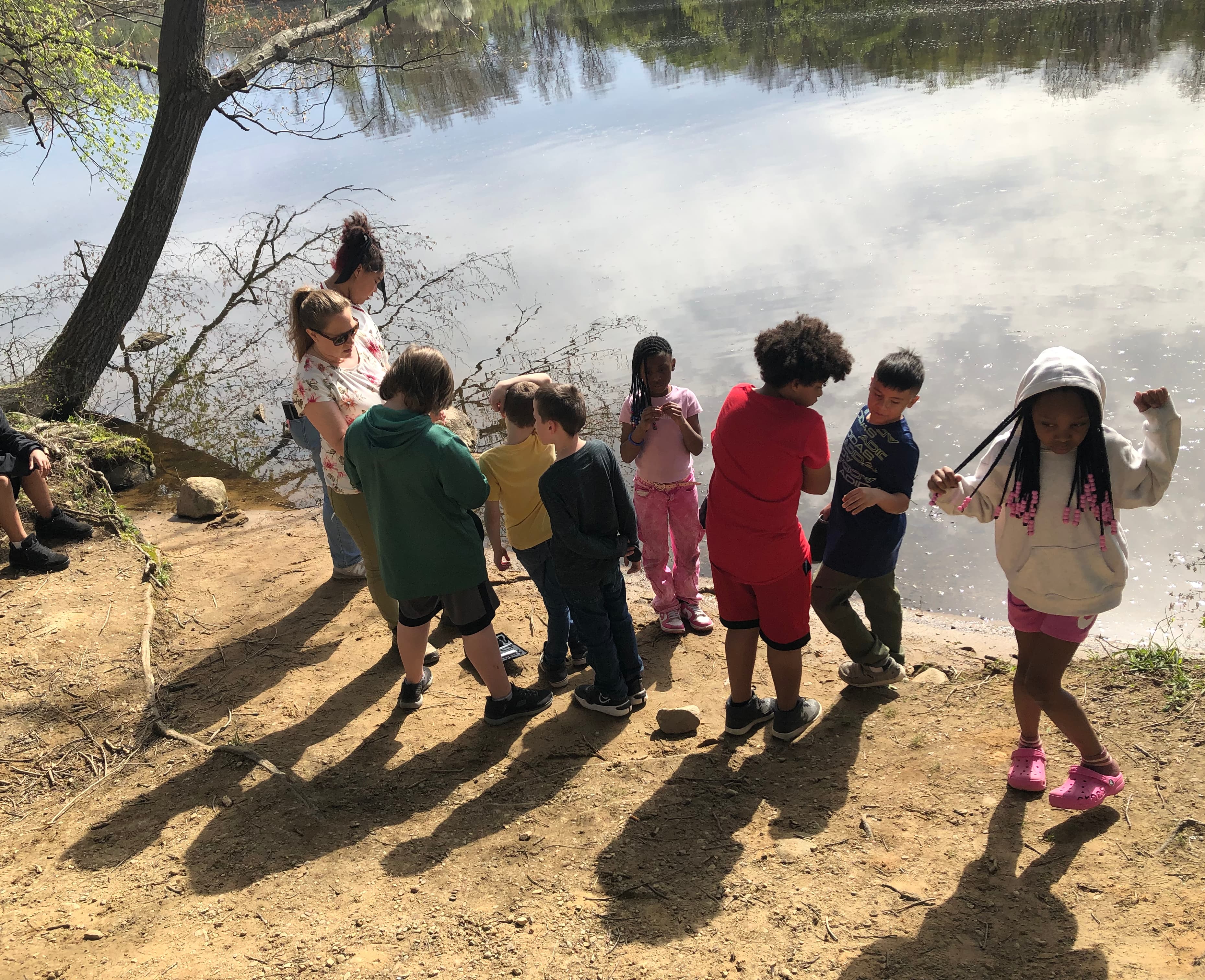 Kids stand next to a river