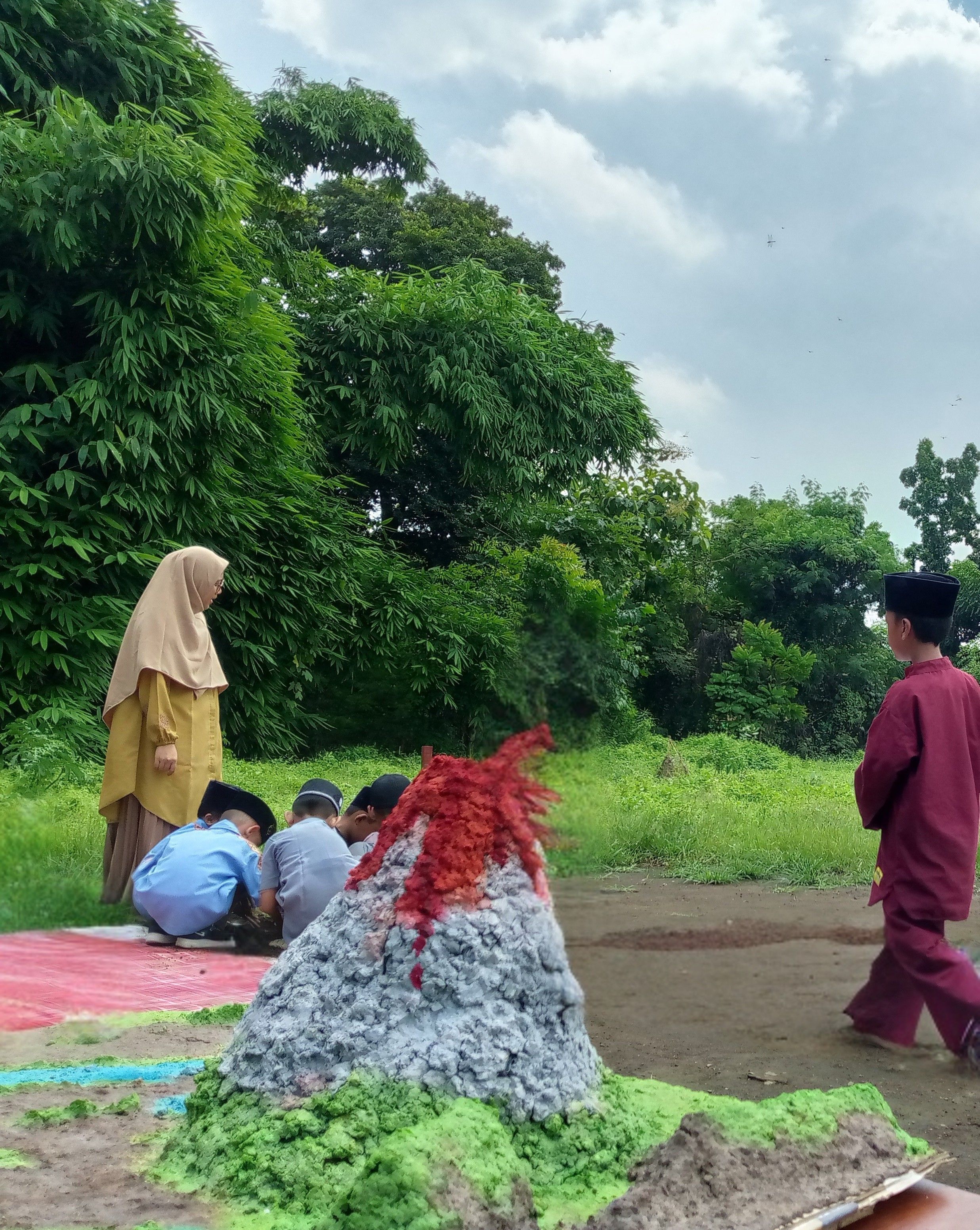 Cardboard mountain in the foreground, with students in the back