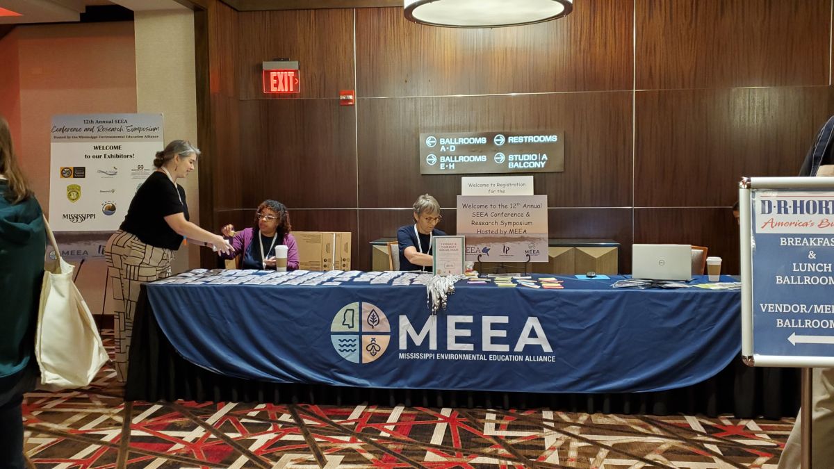 MEEA participates at an event with a table filled with informational literature. 