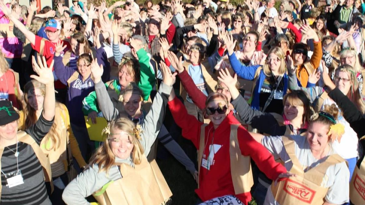 A group of smiling adults extend their arms together. Photo credit: Laura Downey
