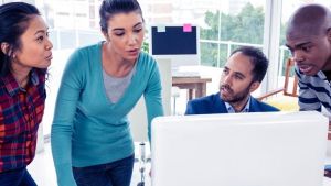 Four people in front of a computer deliberating