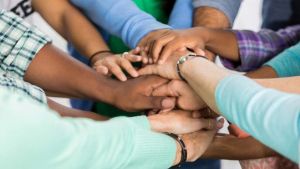 Many hands joined together in a circle. 