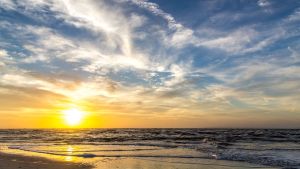 The sun rises at the beach on a cloudy morning over Amelia Island, Florida.