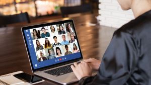 Person using laptop for zoom call with multiple participants.