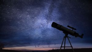 Telescope against a backdrop of a plethora of stars amidst midnight blue