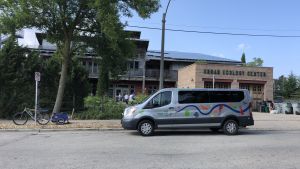 Photo of a gray van parked next to a brown building