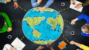 Eight diverse adults sitting around a chalk drawing of earth.