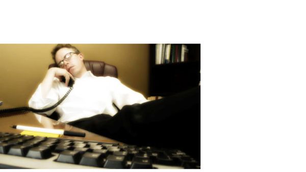 man behind desk asleep with telephone in hand