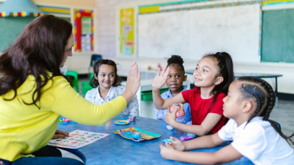 Teacher high-fiving four smiling students