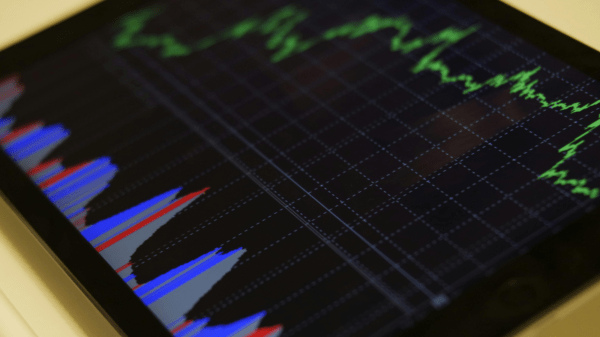 Data Graph A tablet sits on a table; at the bottom of the screen is a graph with three alternating colors: blue, red, and gray; at the top is a varying bright green line