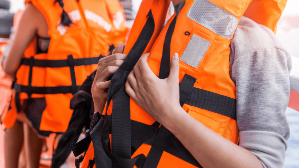 Taking Students Outside Zoomed in on two people in bright orange life vests, view of heads cut off by the image ending