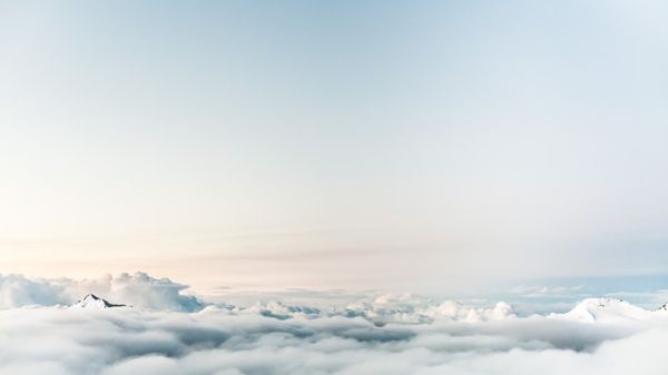 Photo of clouds and the very peaks of a mountain range