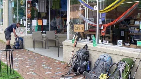 Trails contribute to local economies Backpacker outside retail store