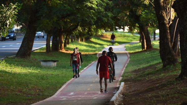 People walking and riding bikes on a bikeway through a park