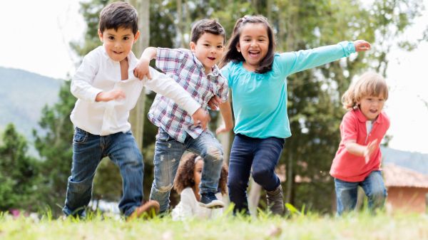 Kids racing up a grassy plain.