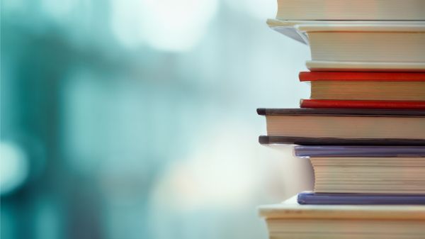 Book stack in the library room and blurred bookshelf