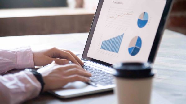 Person working on laptop featuring data visualizations.