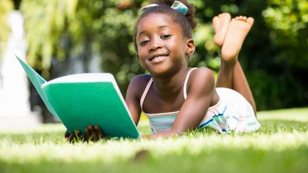 young girl reading outside