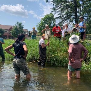 MS engaging in students field. Students standing in bank water and shore.