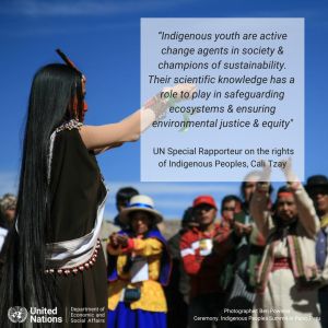 Group of Indigenous People gather outside on a sunny day. Light white transparency with black text says, "Indigenous youth are active change agents in society and champions of sustainability. Their scientific knowledge has a role to play in safeguarding ecosystems and ensuring environmental justice and equity."