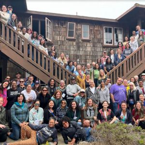 A group of WTRE participants standing in front of a wooden building for a group photo