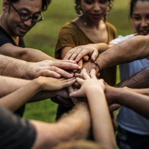 group of people in circle with hands in center