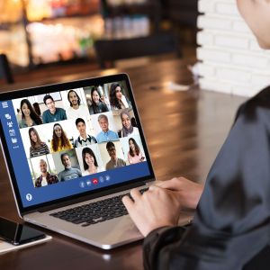 Person using laptop to join a virtual meeting with 15 participants.