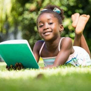 young girl reading outside