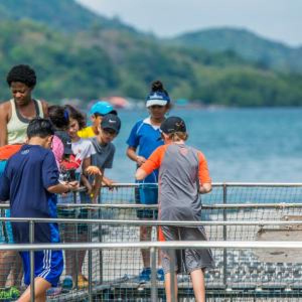 Group of students with teacher at an aquaculture facility.